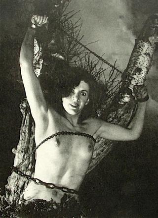topless B movie starlet chained to a tree