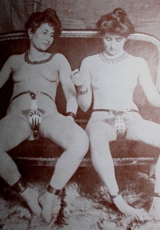 two women on a couch wearing chastity belts