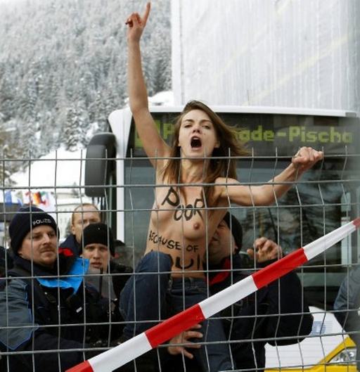 naked protester climbing a fence at davos protest
