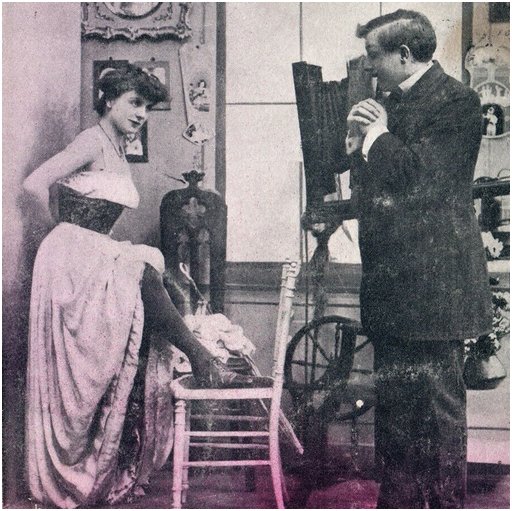 risque photo postcard of a photographer and a woman showing a shapely leg
