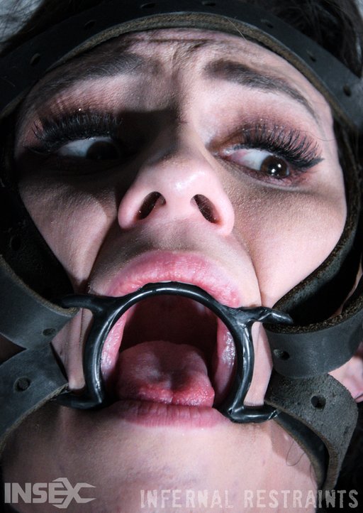 wild eyed and trying to see what is coming through her ring gag forced feeding