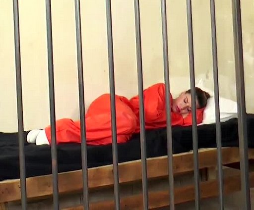 female inmate sleeping in her jail cell