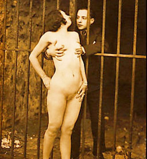 conjugal prison visit, well-dressed man feels up naked woman through the bars