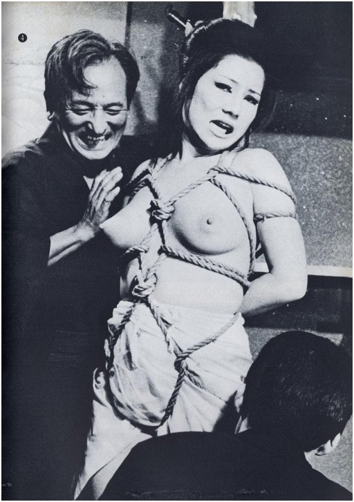 worried looking japanese woman in rope harness being toyed with by two japanese men
