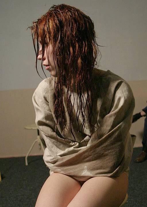 wet woman in a prison straitjacket