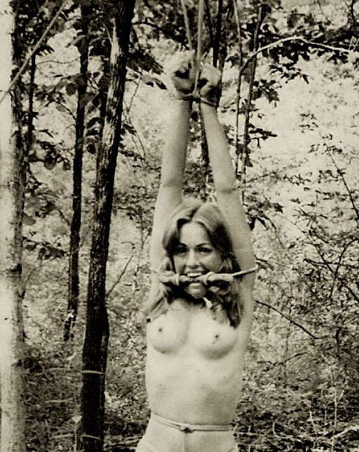 woman tied in the woods and gagged with a tree branch tied in her mouth