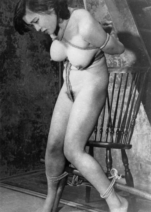 woman tied with rope and a heavy wooden dowel in vintage Japanese rope bondage